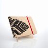 Libreta forrada en lino tono miel con estampado rojo, sobre una base de madera de la marca Leaftones creada por Diana Herrera Design
