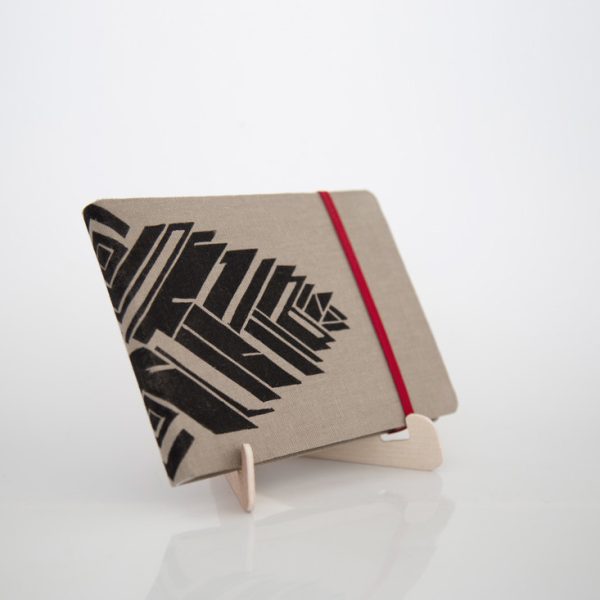 Libreta forrada en lino tono moca con estampado negro, sobre una base de madera de la marca Leaftones creada por Diana Herrera Design